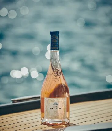 Château d’Esclans rosé bottle on a yacht deck with sea in the background