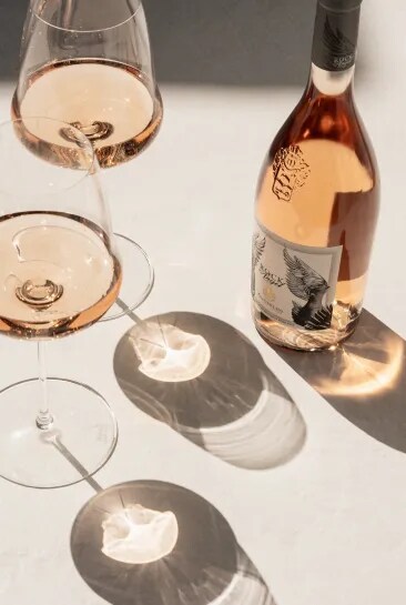 Rock Angel bottle with two glasses creating reflections in soft sunlight