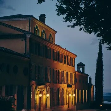 Château d’Esclans building at sunset with glowing lights and evening atmosphere
