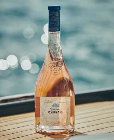 Château d’Esclans rosé bottle on a yacht deck with sea in the background