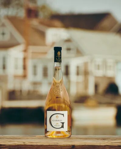 Garrus rosé bottle placed on a table with a blurred estate building in the background